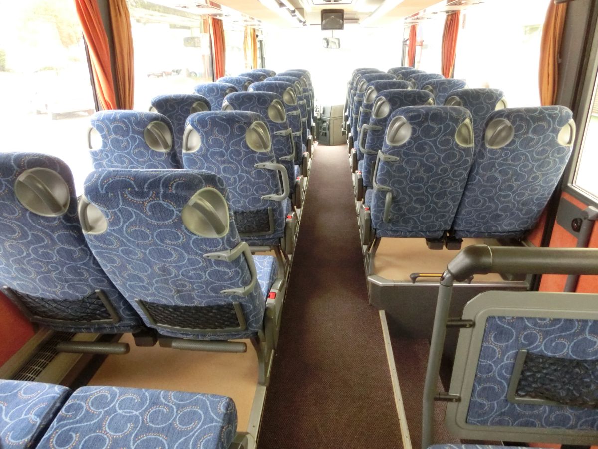 Innenraum des Setra S 315 UL-GT von Josef Kalb aus Norlaching bei Dorfen.
Verbaut sind hier 51 Fahrgastsitze plus 2 Reiseleiterplätze. Die Fahrgastsitze sind Schlafsessel vom Modell Setra 'Top', die über Kurbelarmlehnen, Gurte, Fußrasten und Lederkopfteile verfügen und auf den 330 mm hohen Podesten montiert sind. Auch der Mittelgang ist in diesem Fahrzeug erhöht, sodass sich der gesamte Innenboden auf dem Niveau der H/GT-Modelle befindet. Zur weiteren Innenausstattung gehören die Reisebus-Innenbeleuchtung, Deckensets mit Lüftungsdüsen und Leselampen, Vorhänge und eine TV-Anlage mit DVD-Laufwerk und zwei Monitoren.