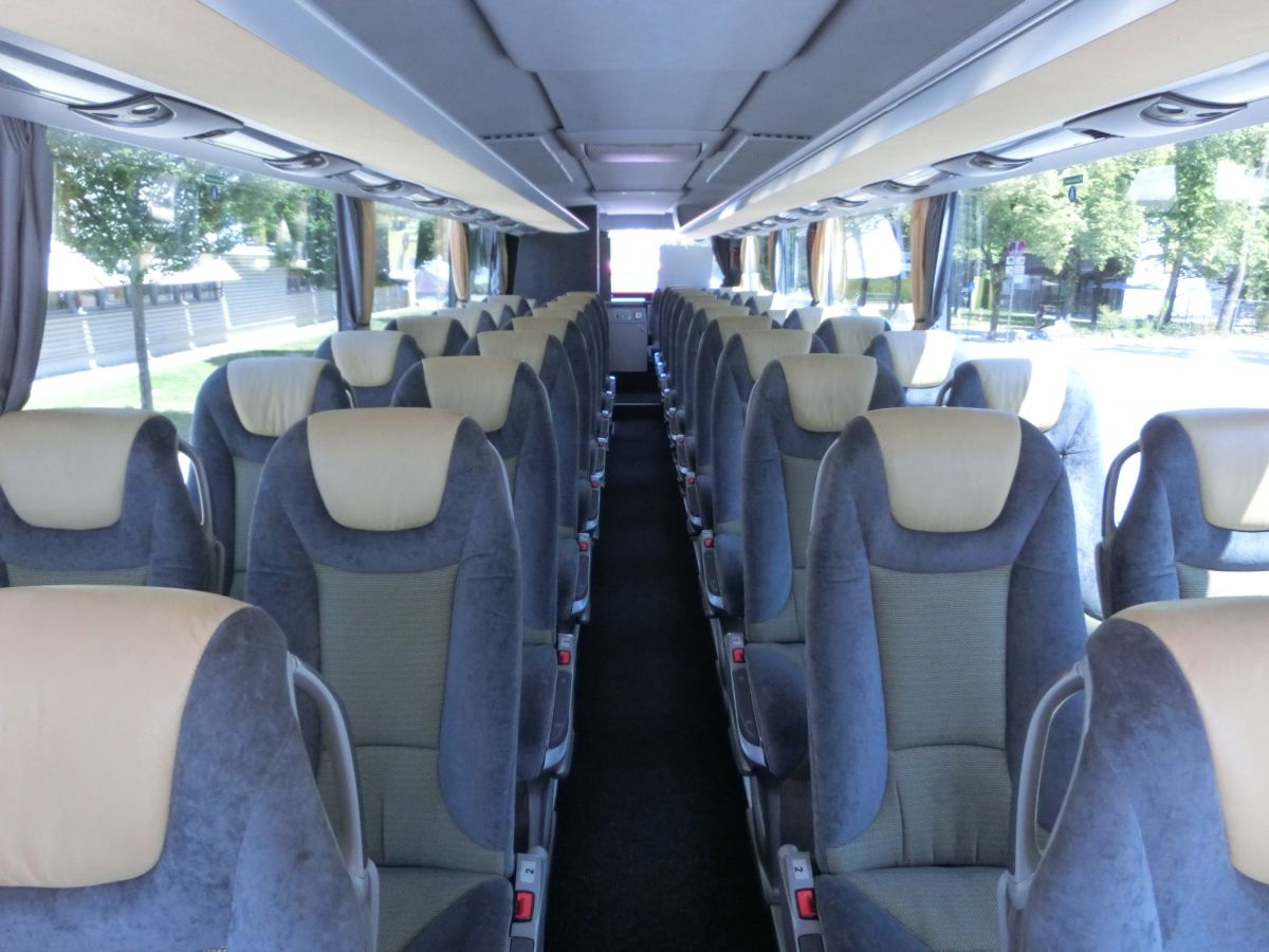 Innenraum des Setra S 415 GT-HD mit Hecktür (Jahrgang 2012) von Perseus-Reisen aus Neumarkt-St. Veit. 42 Setra-Schlafsessel (zzgl. Reiseleitersitz) vom Modell 'Voyage Supreme' mit Lederkopfteil, Klapptischchen und Fußrasten, eine TV-Anlage mit zwei ausfahrbaren Flachbildschirmen und ein Fußboden in dunkler Holzoptik gehören neben der im Heck verbauten Bordküche und Toilette zur Innenausstattung. Über den Sitzen befinden sich standardgemäß Service-Sets mit Düsen und Leselampen.