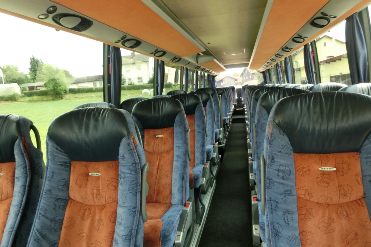 Innenraum des Setra S 416 HDH der '100 Jahre Otto Kässbohrer Edition' von Perseus-Reisen aus Neumarkt-St. Veit.
50 Schlafsessel vom Modell 'Top' in Ambiente-Polsterung (in der üblichen 2-2-Bestuhlung das Topmodell) mit Lederkopfteil, Klapptischchen, Fußrasten und vielem mehr laden zum Platz nehmen ein. Weiterhin gibt es Deckensets mit Lüftungsdüsen, Leselampen und Lautstärkeregelung für die Lautsprecher sowie Rollos an den Fenstern. Natürlich gehören auch Bordküche und Toilette zur Ausstattung.