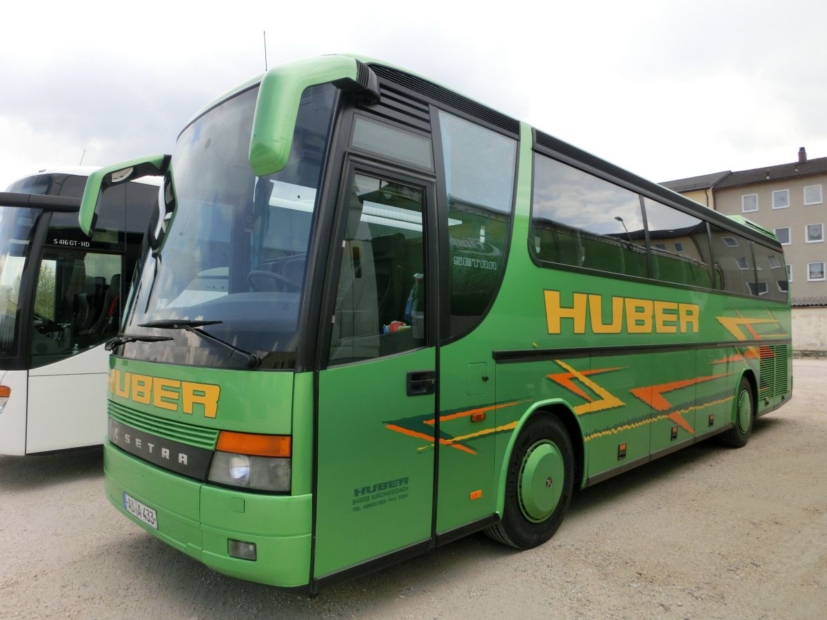 Setra S 312 HD Compact von Huber aus Kirchweidach. Dieses mit 41+2 'EC'-Schlafsesseln mit Lederkopfteil und der f�r die Ausstattungsvariante Compact typischen Dachklimaanlage ausgestattete Fahrzeug d�rfte in den Bauzeitraum 1997-1999 einzuordnen sein. F�r den Antrieb sorgt ein stehend eingebauter V-Motor von Mercedes-Benz (vermutlich der V8 Typ OM 442 LA mit 280 kW (381 PS)) und das pneumatische Achtgang-Handschaltgetriebe ZF 8 S-180.
Am 30. 4. 2015 konnte der sch�n anzuschauende Reisebus auf dem Dultplatz in Alt�tting aufgenommen werden.